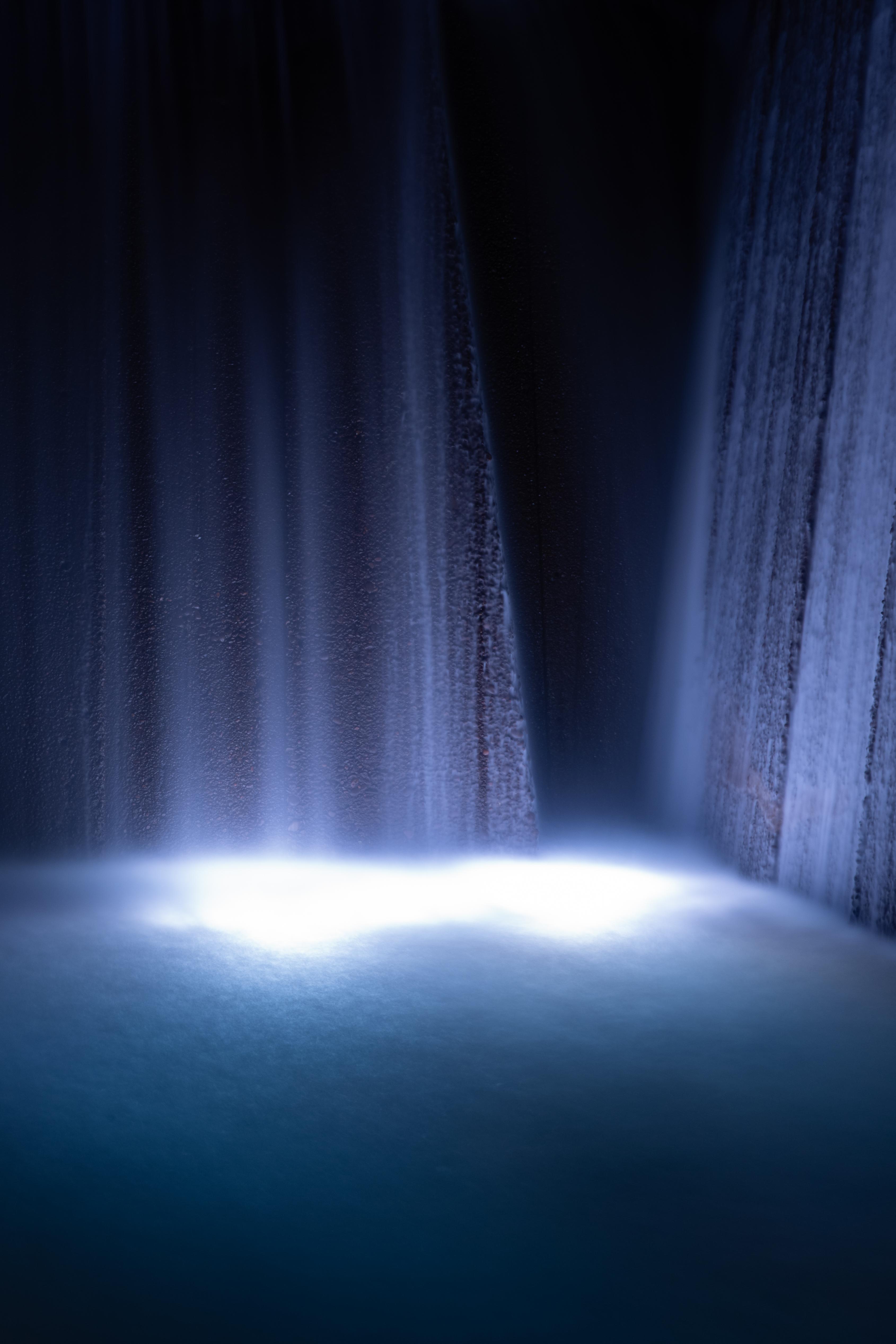 A waterfall with a light below it. Very peaceful