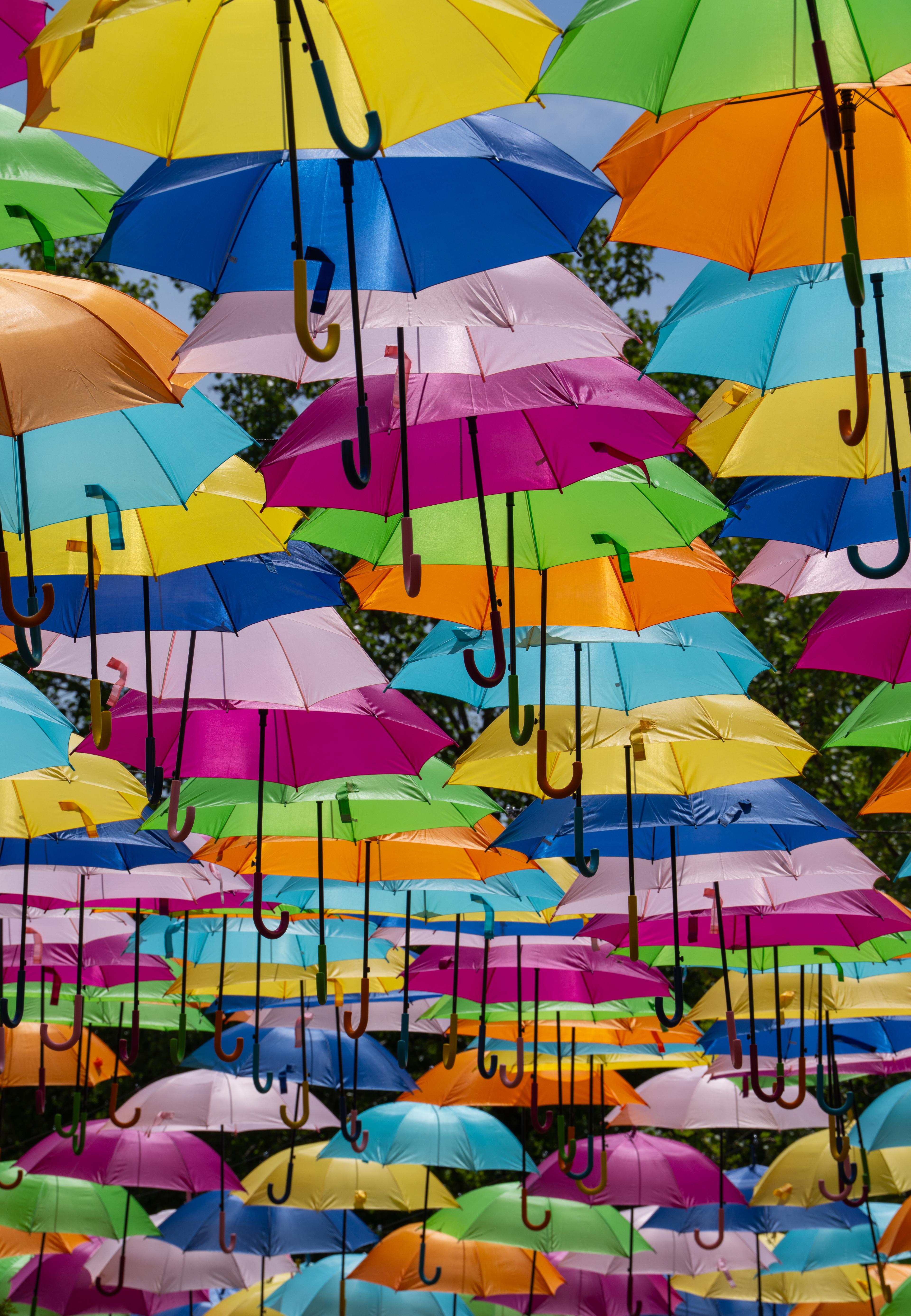 Hundreds of solid colored umbrellas forming a rainbow of color