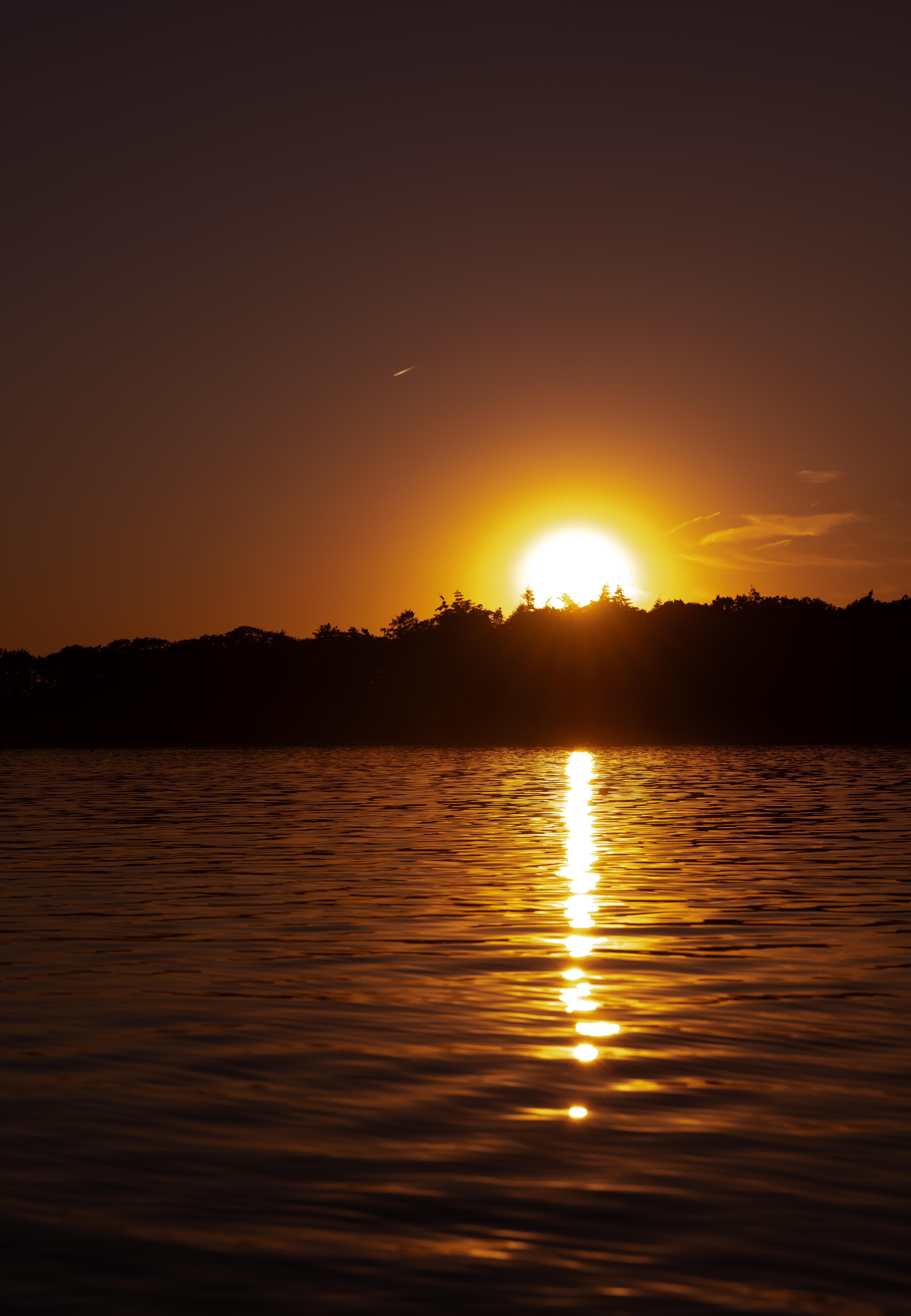 A setting sun over water ripples